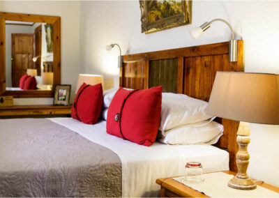 Oakdene Guest House bed with two red pillows